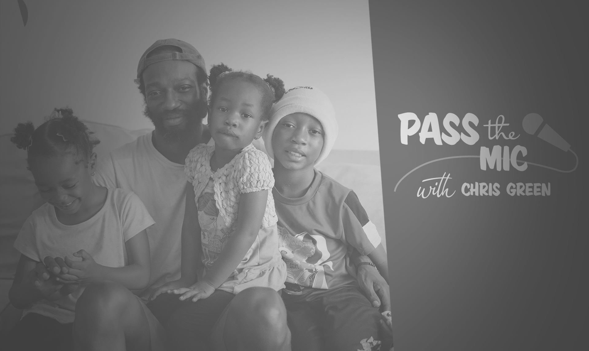 A family of four sit on the couch: a father, two girls and a boy. 