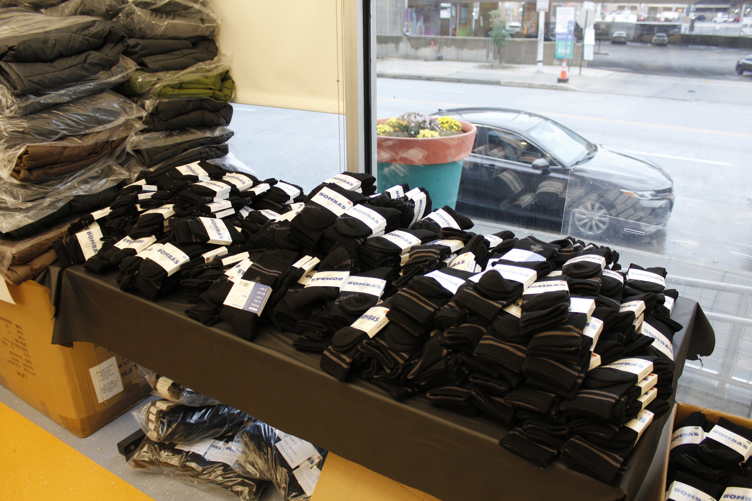A pile of pairs of black socks on a table.