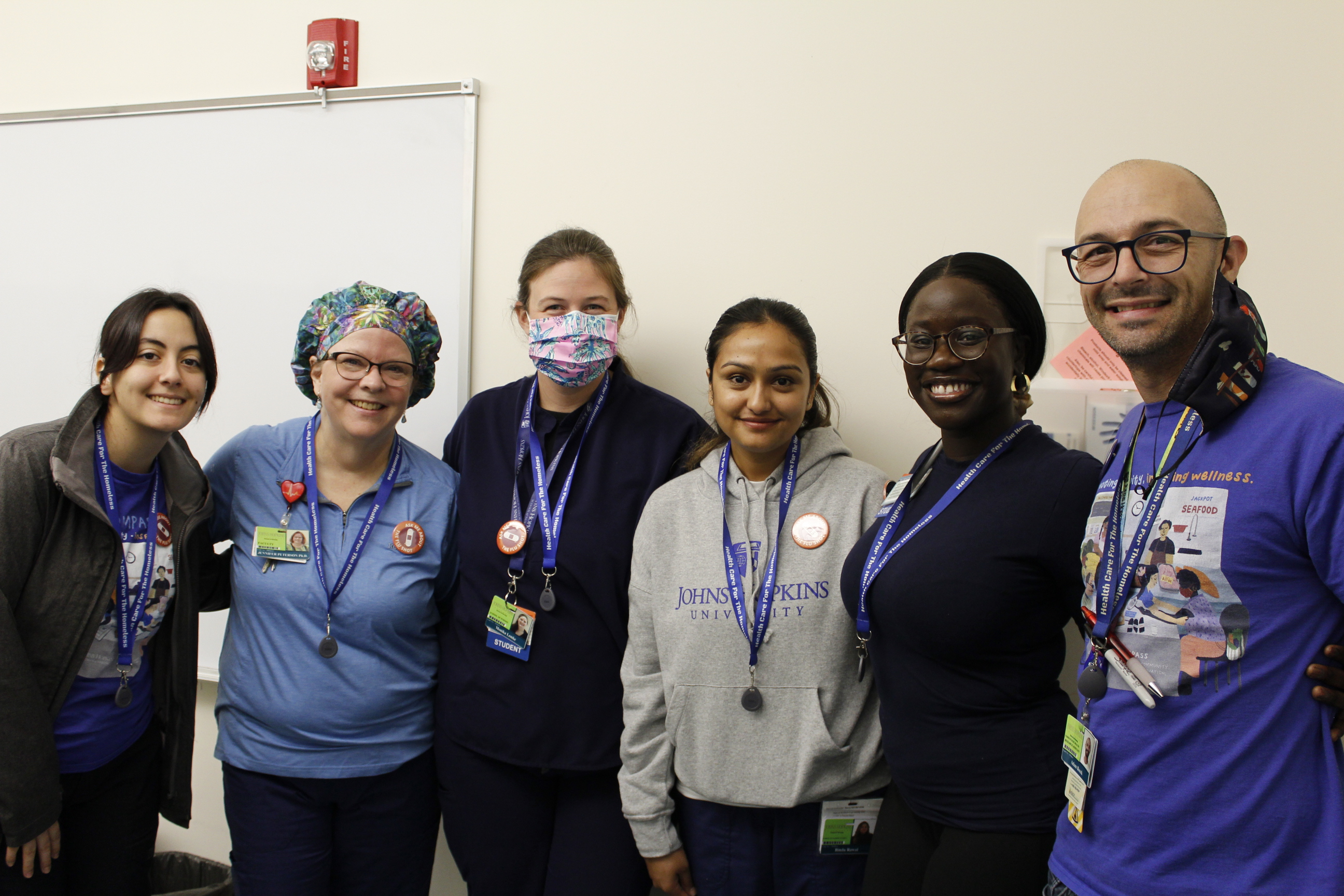 A group of volunteer nurses and nursing students smile together.