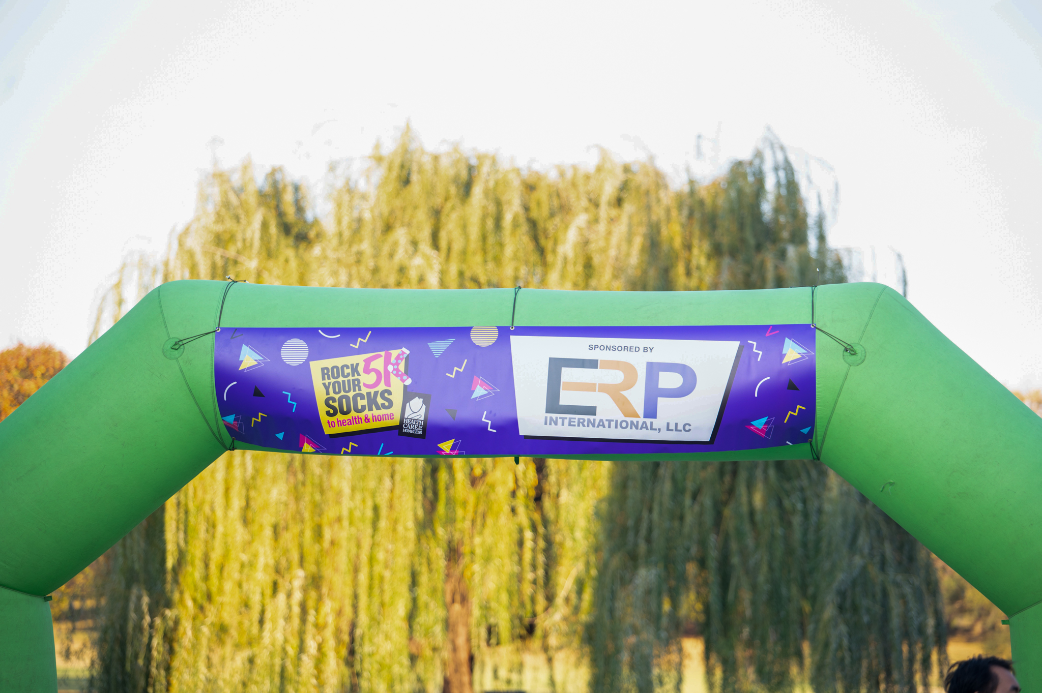 The sponsor banner hangs from the top of the green finish line arch.