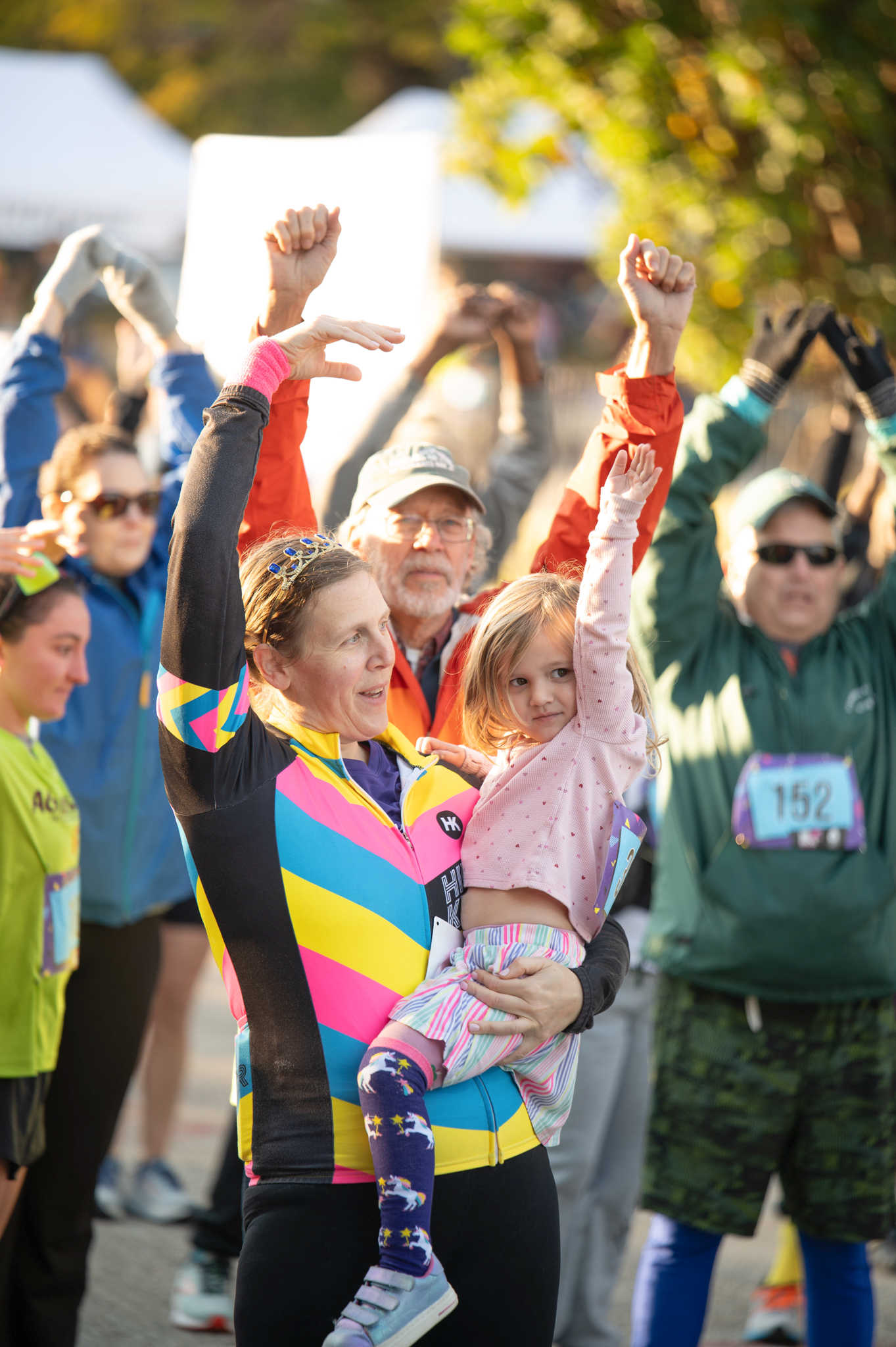 A group of 5K participants stretch their arms up.