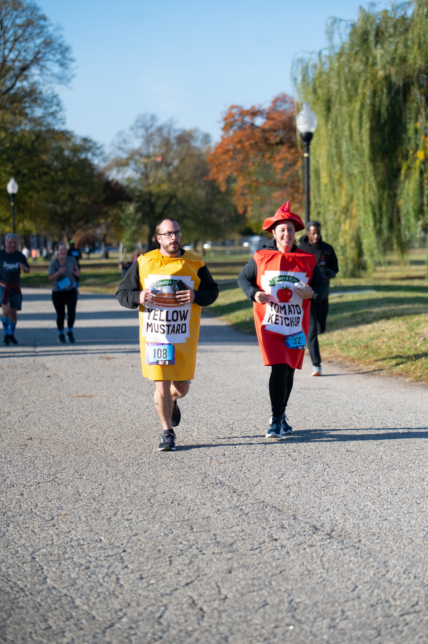 A light-skinned man dressed as mustard and a light-skinned woman dressed as ketchup job