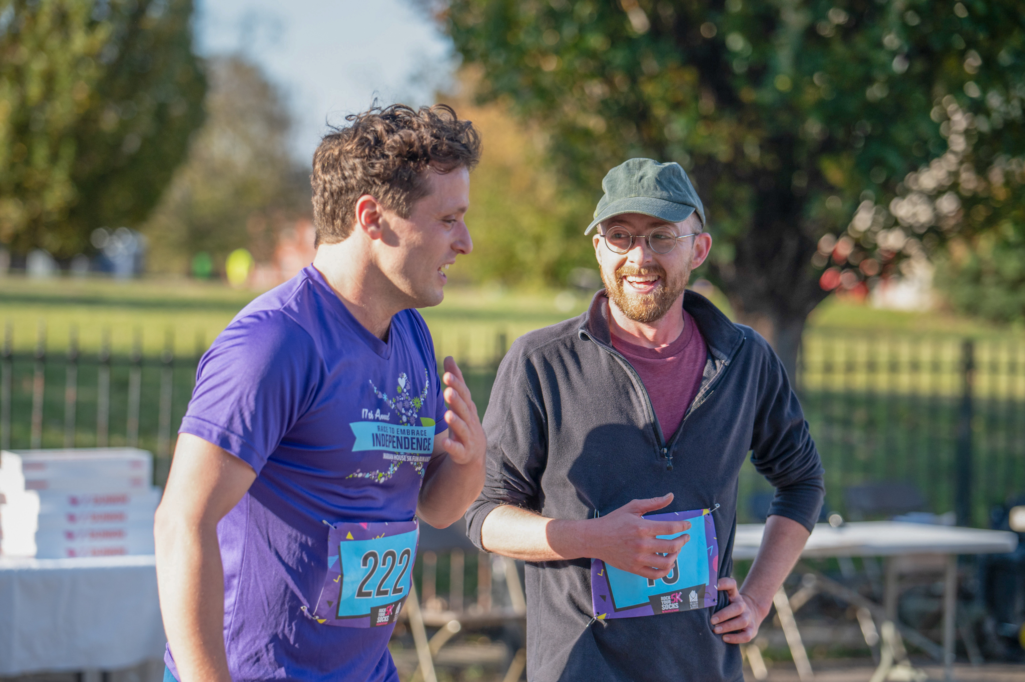 Two light-skinned men talk after crossing the finish line