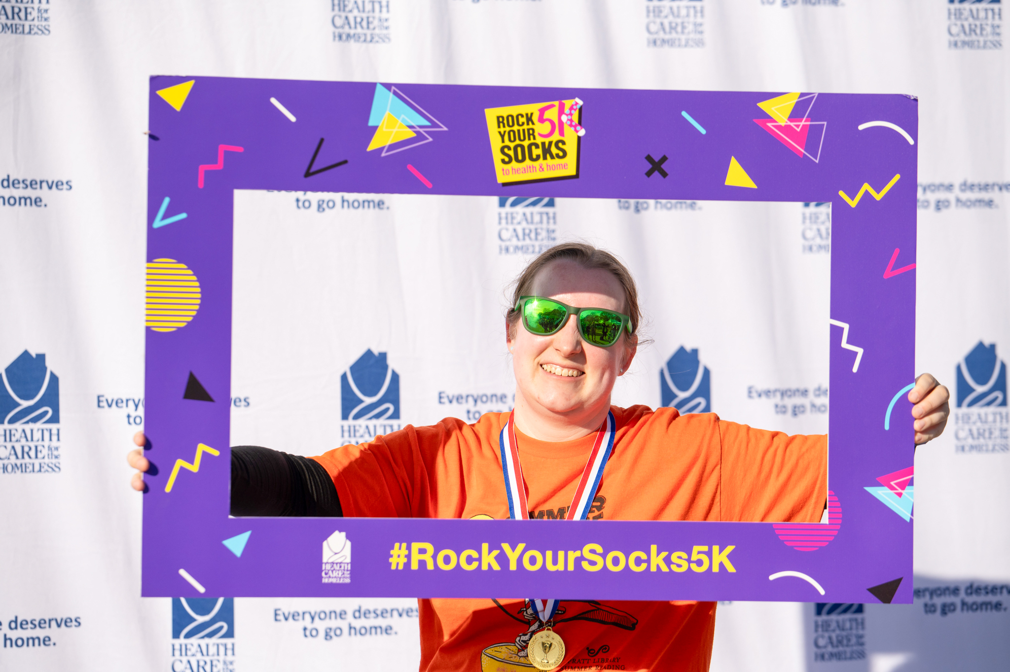 A light-skinned woman smiles while holding the purple photo frame