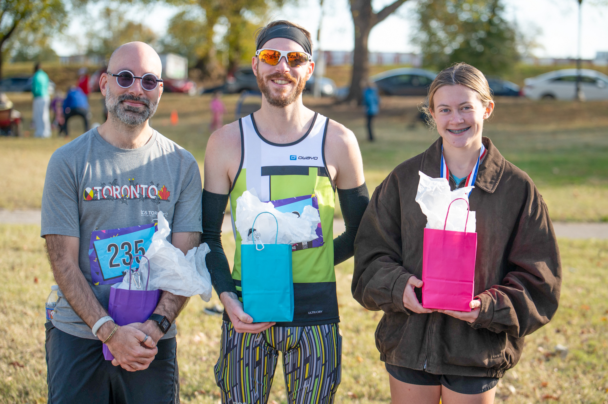 Three people hold gift bags