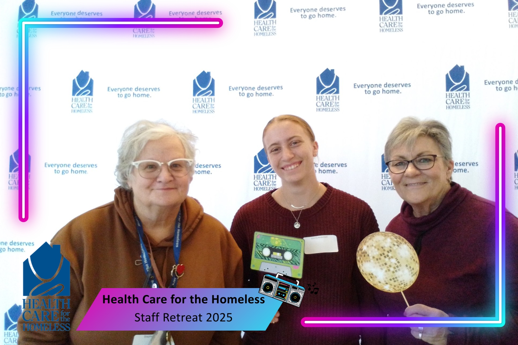 People in front of a blue and white backdrop holding 80s photobooth props