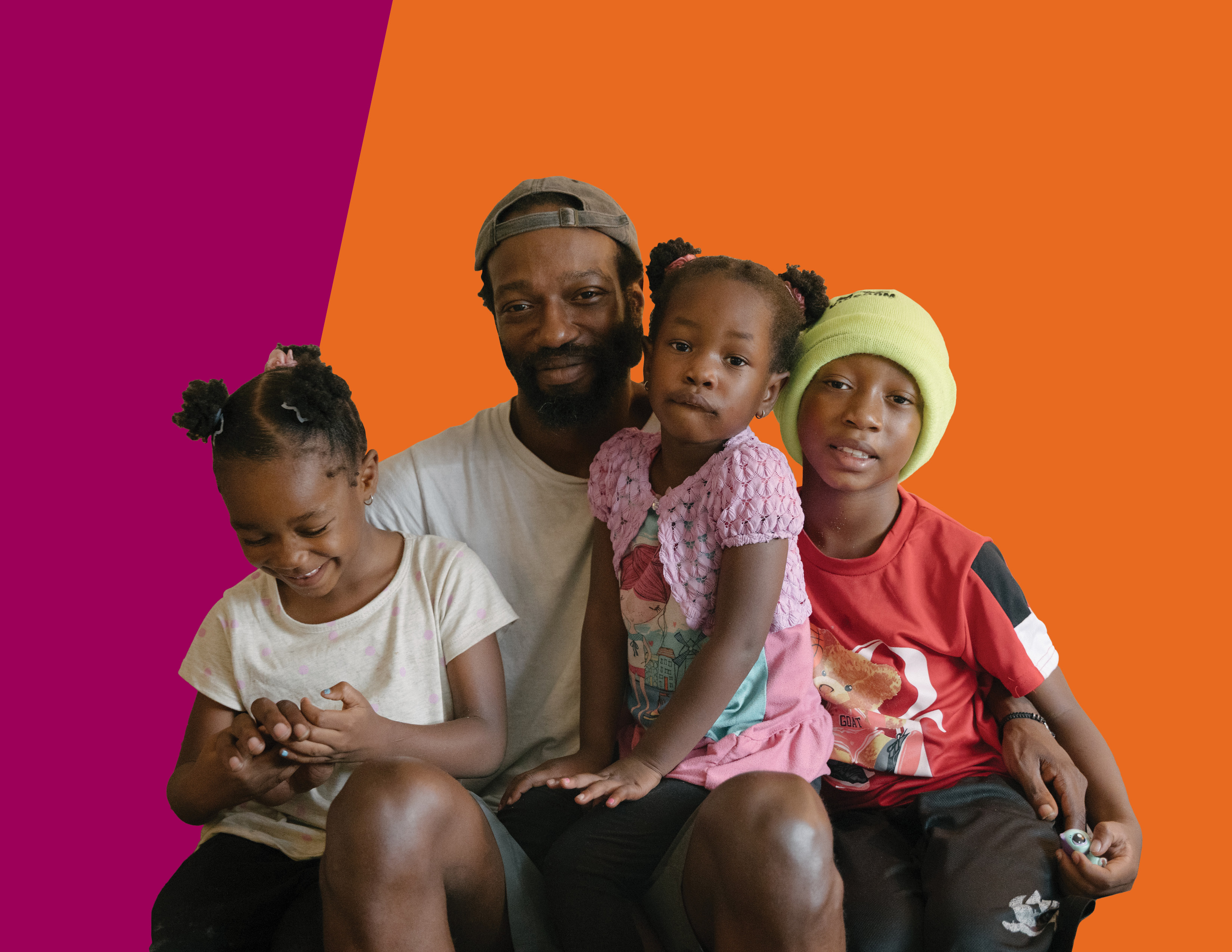 A man sits with his three young children around him