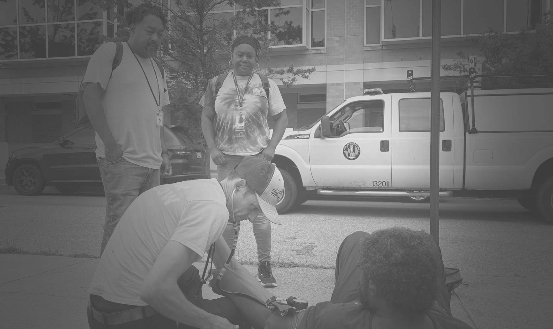 Two onlookers watching someone get checked out by a doctor
