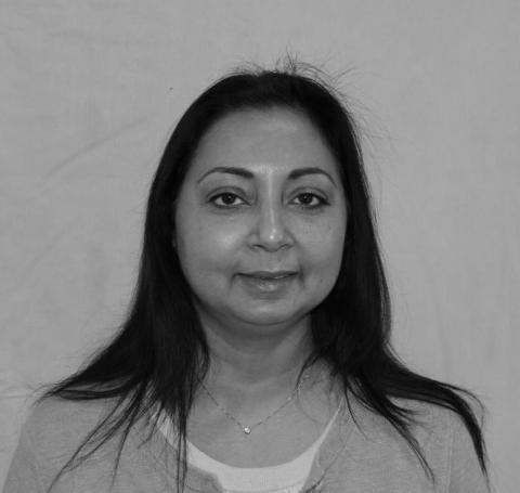A black and white headshot of a medium-skinned woman with long dark hair.
