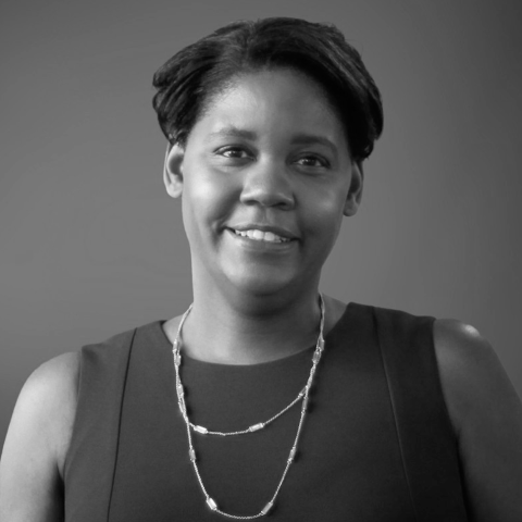 A black and white headshot of a dark-skinned woman with short dark hair.