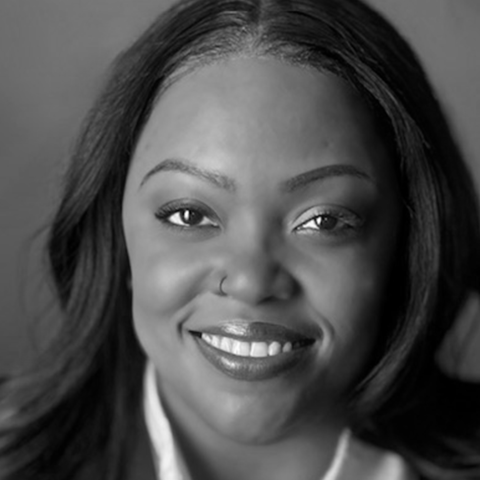 A dark-skinned woman with dark shoulder-length hair.