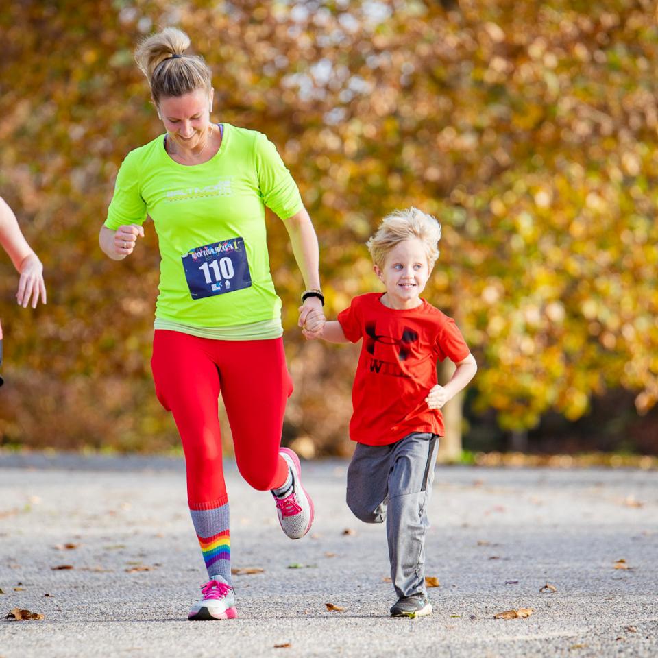 Christina Bauer, blonde woman in bright neon clothes, running with her son in the Rock Your Socks 5K