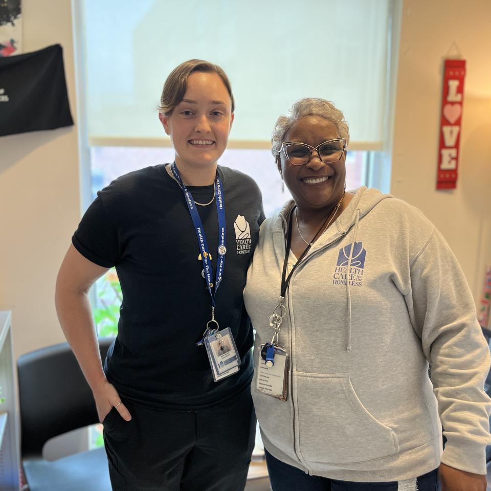 Alex James, RN, LMSW (L), a light-skinned person with short brown hair, stands next to Tammy Montague, PhD, LCSW-C (R), a dark-skinned woman with glasses and short grey hair.