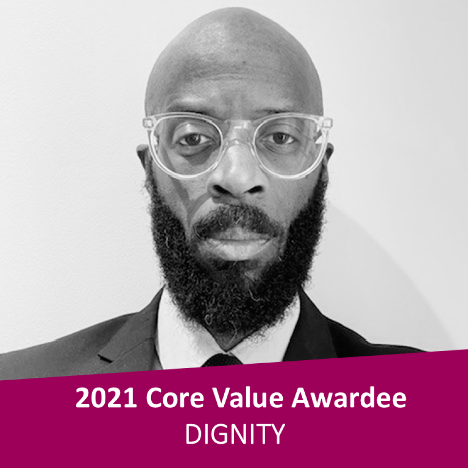 A dark-skinned man with glasses and a beard with a 2021 Core Values Awardee banner below the photo.