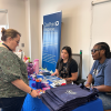 A person speaks to two sitting people at a table for CarePoint Response.